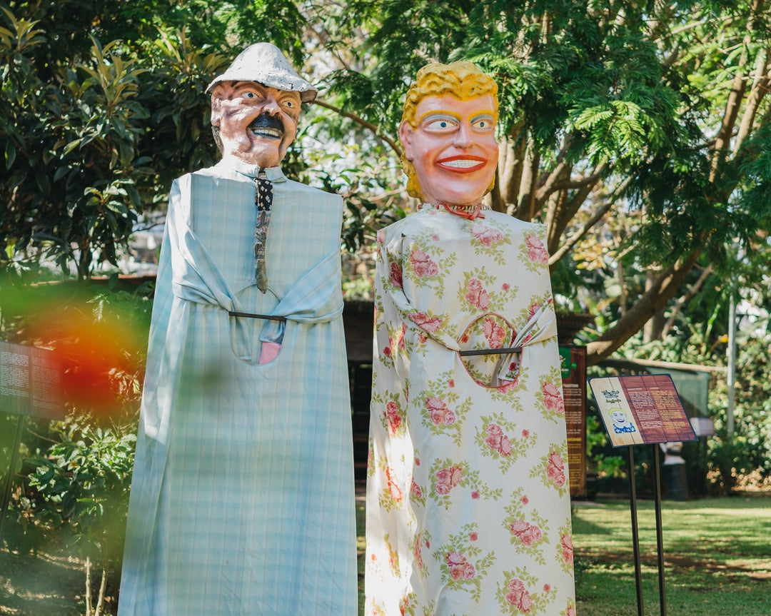 Traditional Costa Rican masquerade figures displayed in the gardens of the Britt Coffee Tour in Costa Rica.